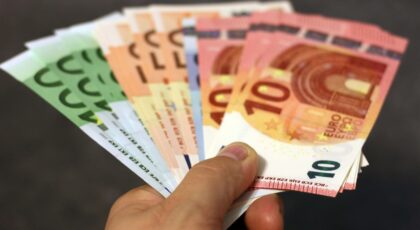 Šalia sudėti įvairios vertės eurų banknotai