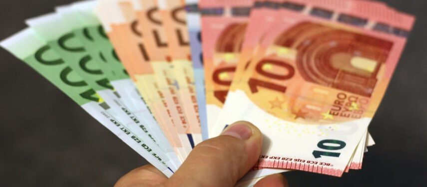 Šalia sudėti įvairios vertės eurų banknotai