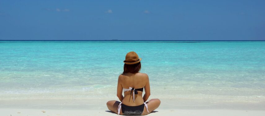 Moteris, sėdinti paplūdimyje prie jūros, asociatyvi nuotr., Pexels