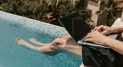 Žmogus dirba kompiuteriu prie baseino