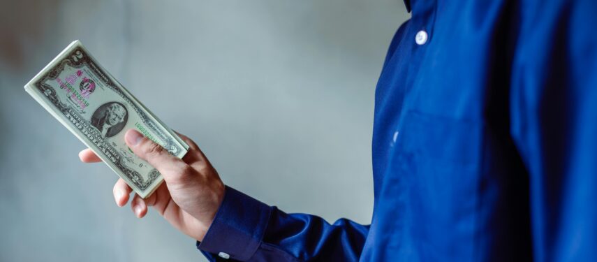 Žmogus rankoje laiko grynuosius pinigus, Aukid phumsirichat'o nuotr.