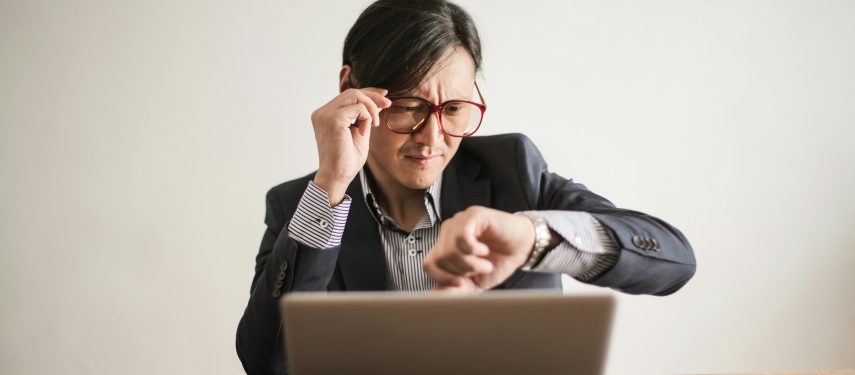 Pasimetęs darbuotojas tikrina laiką laikrodyje, Andrea Piacquadio nuotr.