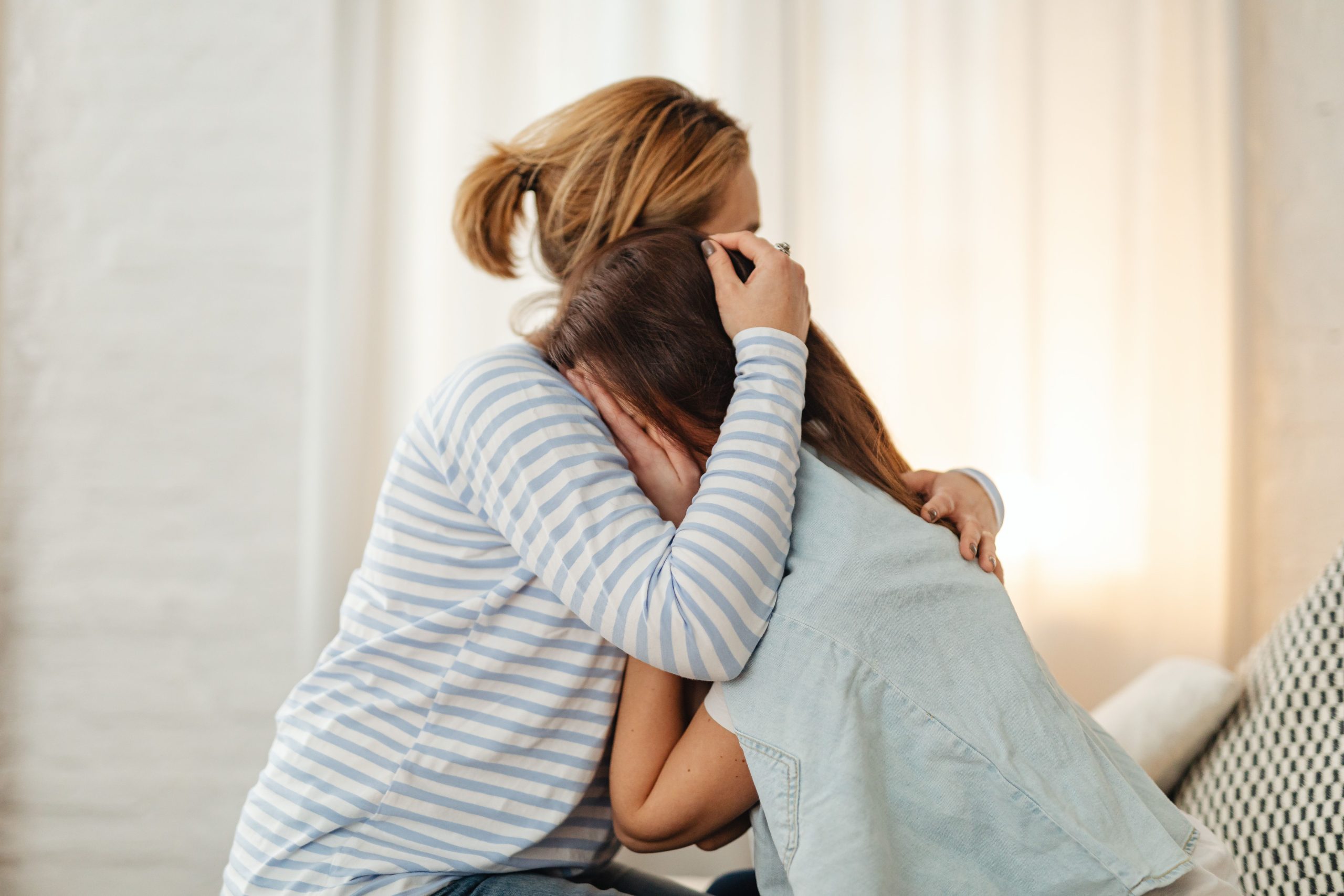 Moteris apkabinusi vaiką, kuris užsidengęs veidą rankomis, pexels.com nuotr.